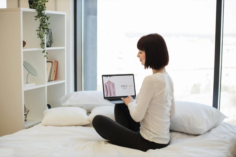 Woman with laptop browsing website with clothes on sale